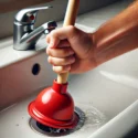 cup plunger being used to unclog a sink: